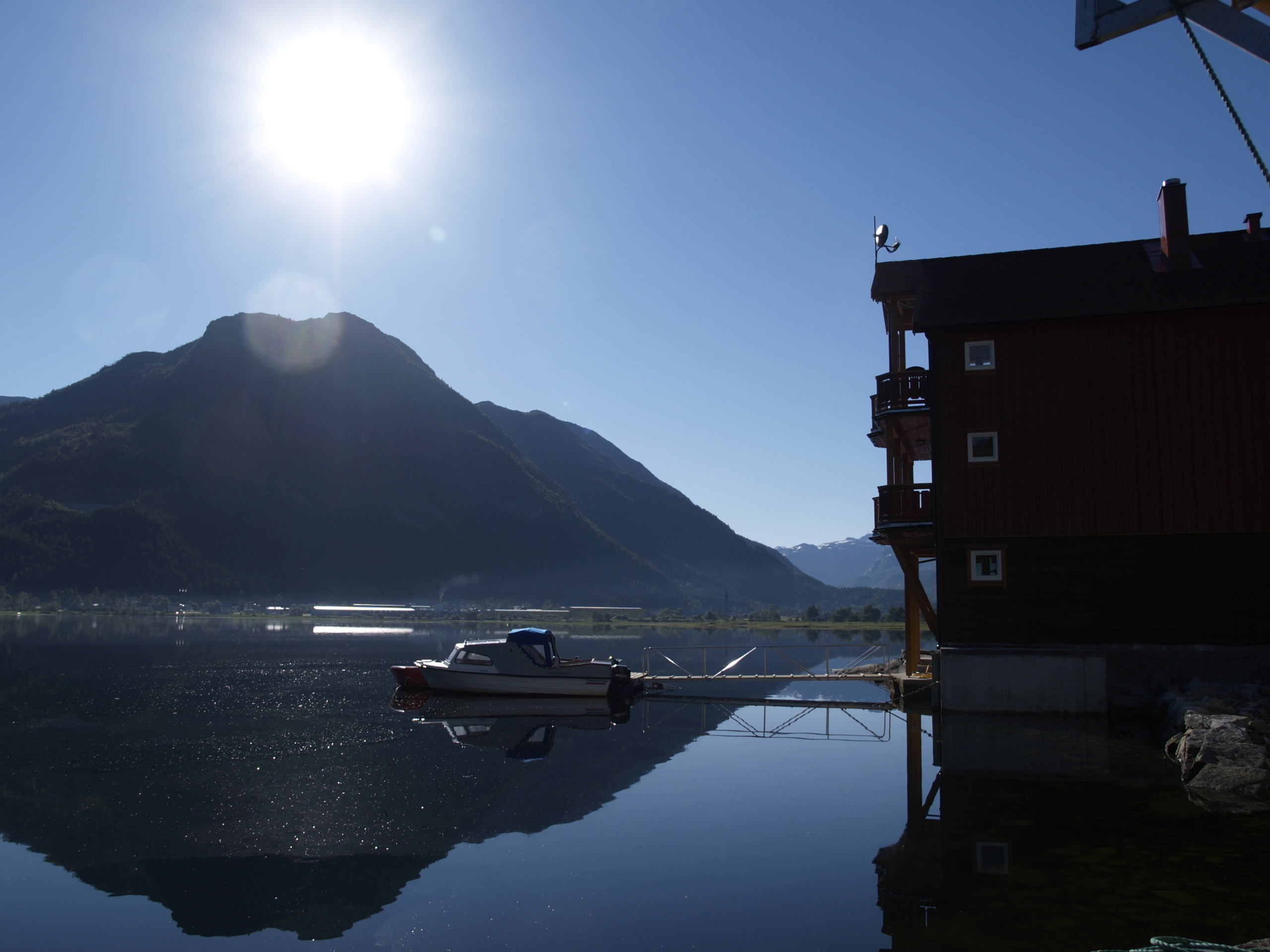 Stille morgen ved brygga med speilblank fjord