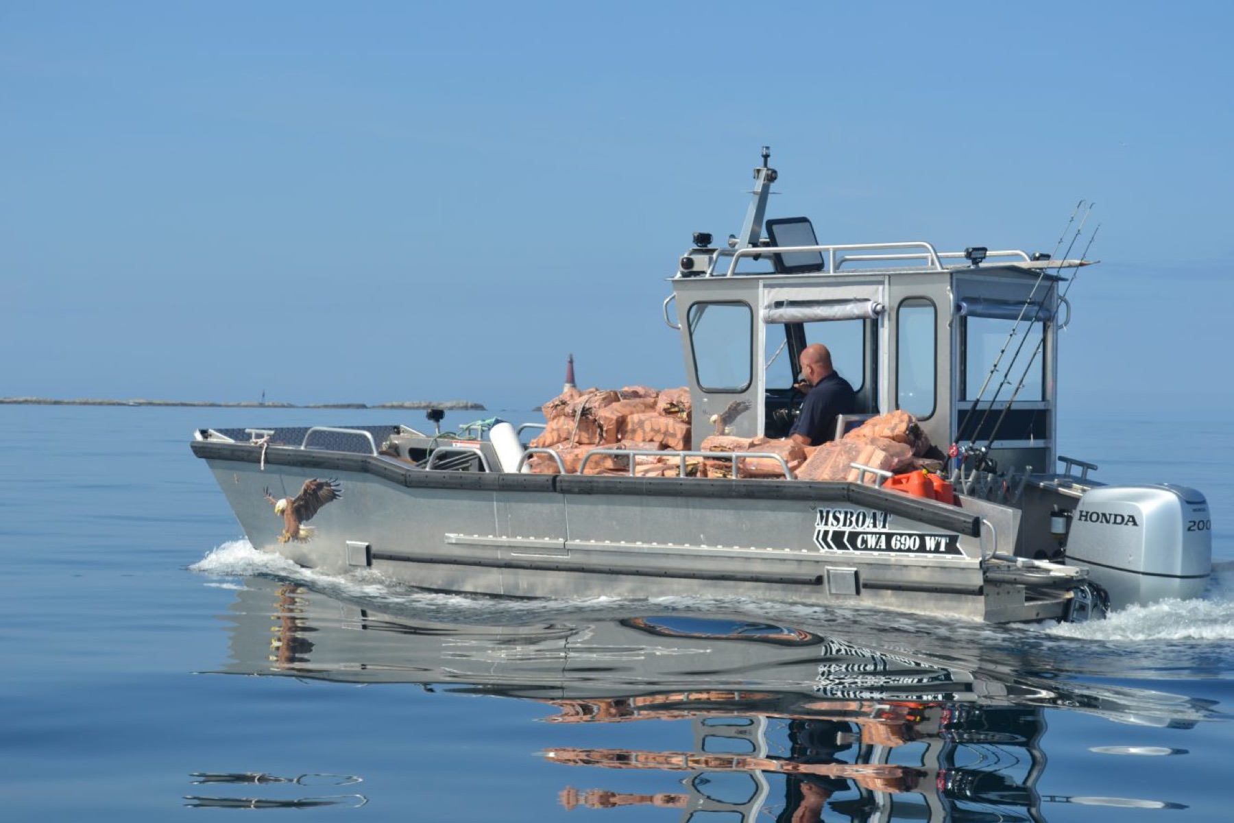 Vedbåten lastet med sekker av tørr bjørkeved på fjorden